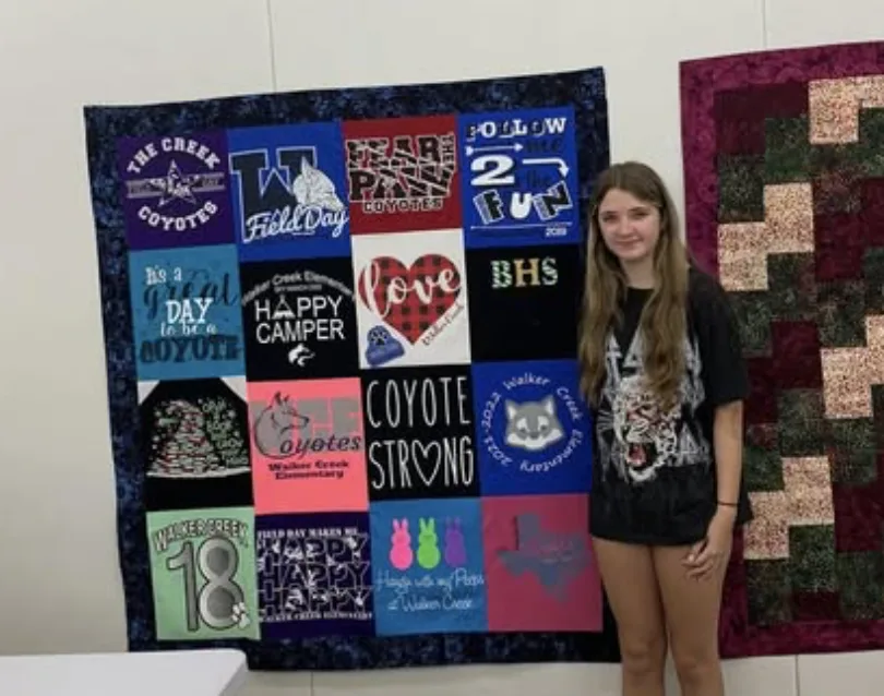 Young quilter with a finished memory quilt