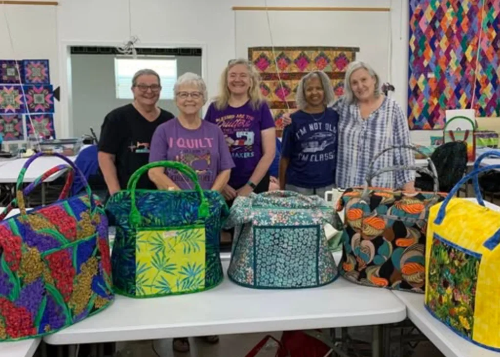 Quilting group showing handmade tote bags