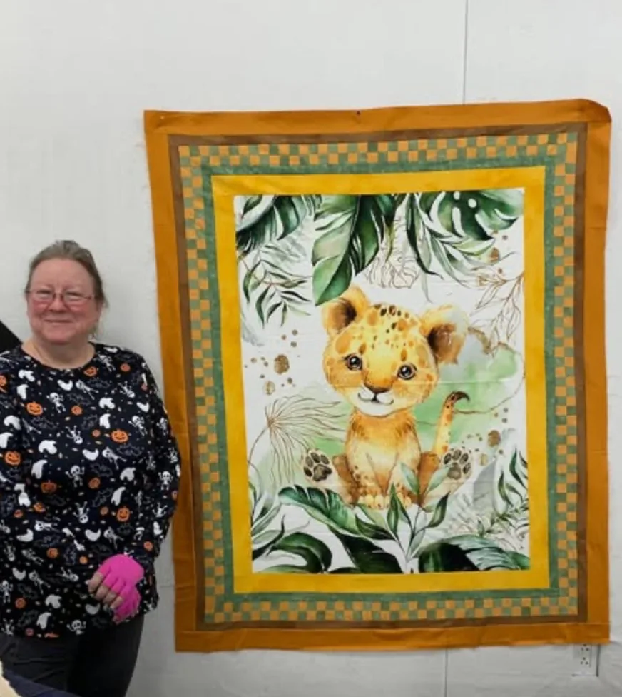 Quilter beside a finished panel project