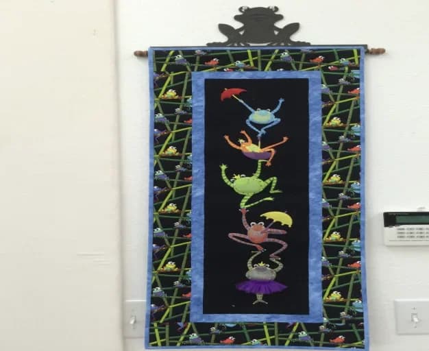 Whimsical frog wall hanging on display