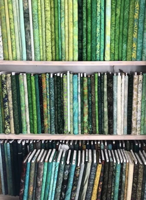 Green and teal fabric bolts on Shoppe shelves