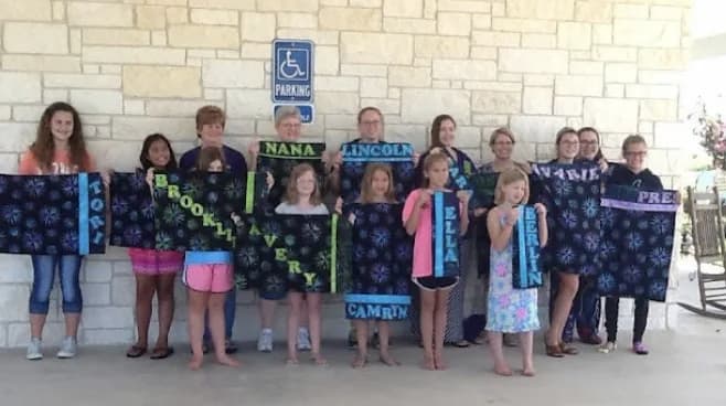 Young makers holding finished projects outdoors