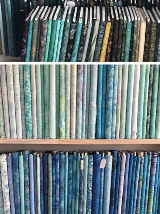 Blue fabric bolts stacked in the Shoppe