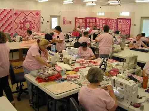 Full workroom of quilters sewing together
