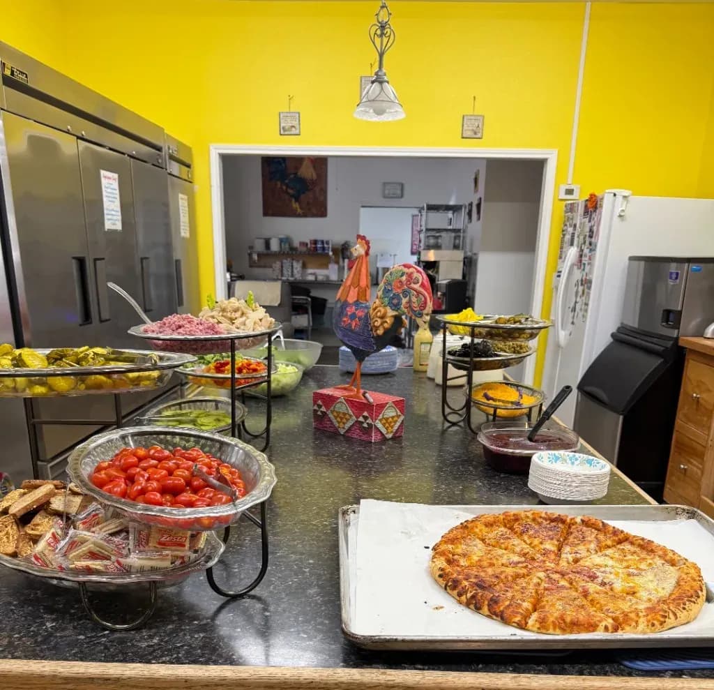 Chef salad bar and pepperoni pizza lunch laid out in the kitchen