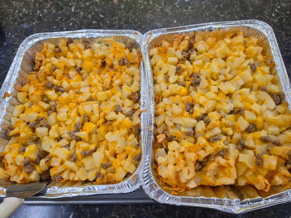 Two pans of potato, sausage, and cheese brunch casserole