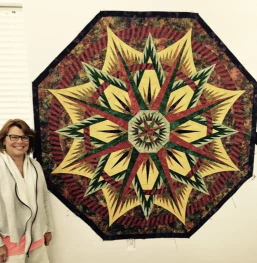 Finished compass-star quilt displayed on the design wall