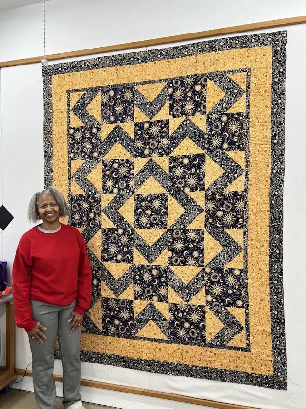 Guest with a navy and gold celestial quilt on the design wall from Shoppe fabric